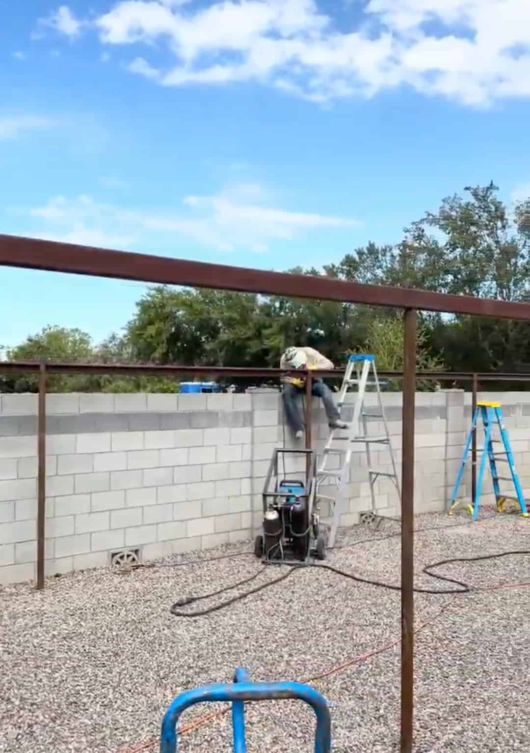 Mobile METAL Medics working on the pipe frame of a custom metal shade structure during construction.